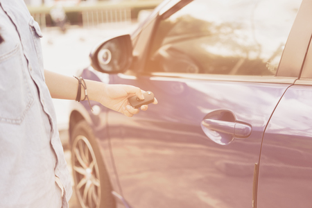 Women teenager hand presses on the remote control blue car in parking area outdoor,retro effectの写真素材