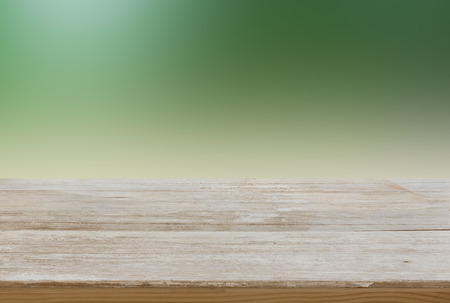 Wooden table top with green blurred background