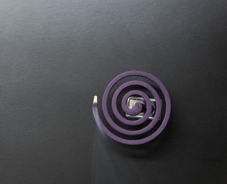 Laverder mosquito repellent with smoke on dark backgroundの写真素材