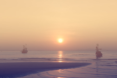 Golden sunset over sea and sky with fishing boat floating ,vintage filter effect