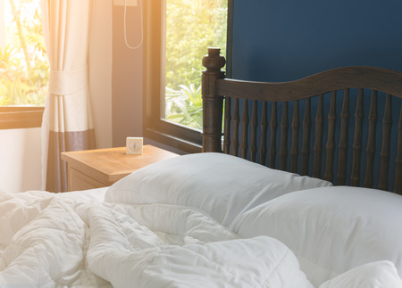 Comfortable of white bedding sheets and pillows with blue wall background,room interiorの写真素材