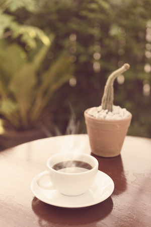 Coffee cup in morning sun light  with green garden background,retro effectの写真素材