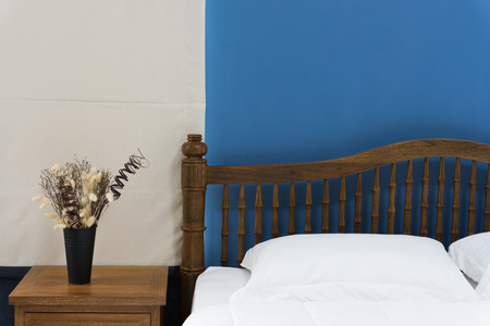 Wooden bed side table decorated in modern with bedroom with beige curtains background