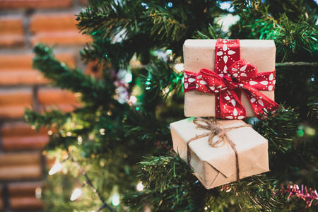 Close up Christmas gift box on pine tree with ribbon and lighting,Christmas background,retro filter