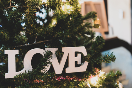 White wood love text decorative on tree with beautiful garland backgroundの写真素材