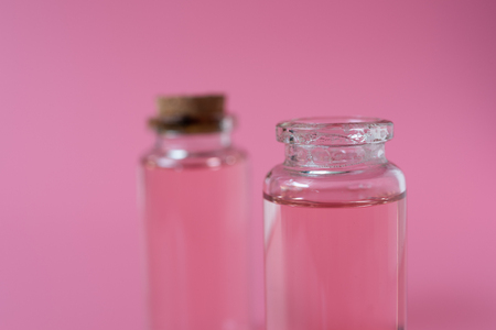 Rose liquid bottle on pink backgroundの写真素材