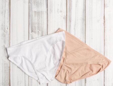 Woman panties set on white wooden background, top viewの写真素材