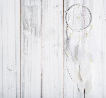 White dream catcher on wooden background, flat layの写真素材