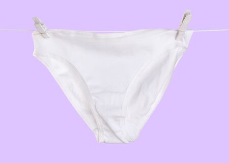 White underwear woman dry on rope isolated on purple background