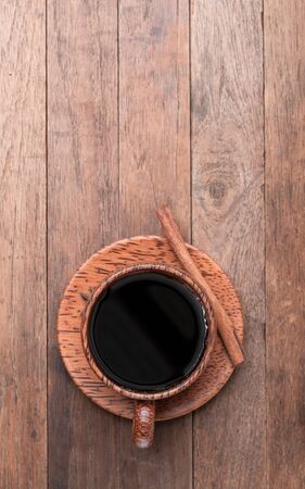 Black coffee in wood cup over grunge wooden table background,top view with copy spaceの写真素材