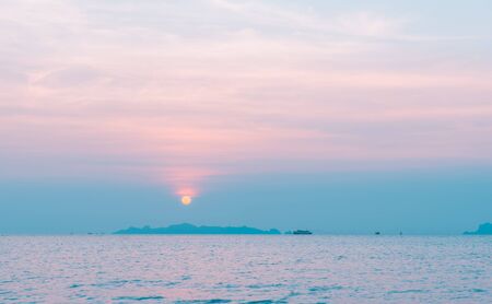 Beautiful pastel beach sunset with blue sea and golden light sky  cloud backgroundの写真素材