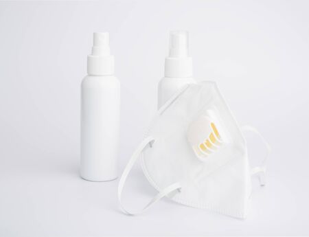 White mask for wearing germ protection  and gel alcohol or hand sanitizer spray bottle for washing hand  to protect from corona cirus set on white backgroundの写真素材