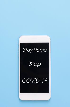 âStay Homeâ text on mobile phone over blue backgroundの写真素材