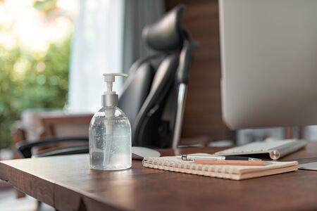 Work from home office gadget hygiene with computer and hand sanitizer protection from coronavirus outbreak or Covid-19の写真素材