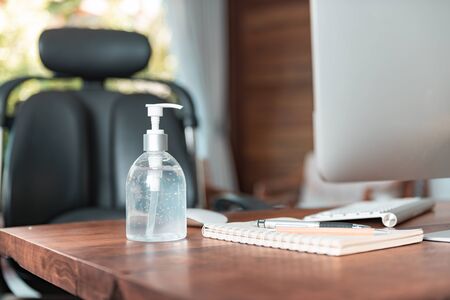 Work from home office gadget hygiene with computer and hand sanitizer protection from coronavirus outbreak or Covid-19の写真素材