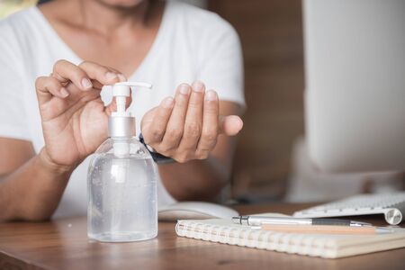 Female washing hand  by sanitizer gel for prevention coronavirus disease (COVID-19) before work from home.の写真素材