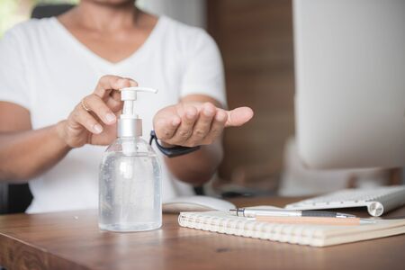 Female washing hand  by sanitizer gel for prevention coronavirus disease (COVID-19) before work from home.の写真素材