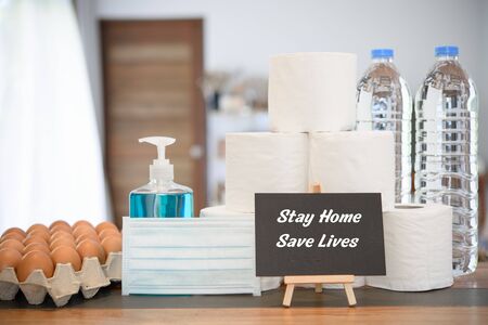 Home quarantine due to coronavirus or  COVID-19 protection with fresh eggs, hand gel,tissue roll,drink water  bottle and black board sign in living roomの写真素材