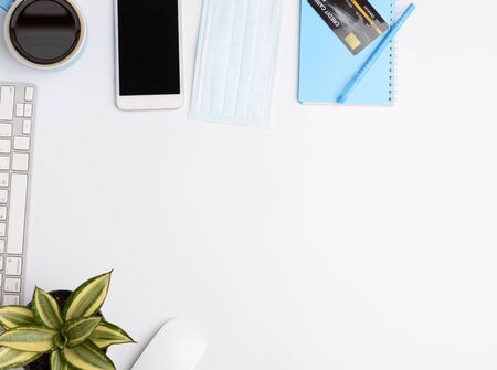 Work from home concept due to Covid-19 or Coronavirus with laptop,anote book ,medical mask,hot coffee,credit card and mouse on white background,flat layの写真素材