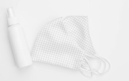 Fabric cloth mask for wearing germ protection  and gel alcohol or hand sanitizer spray bottle for washing hand  to protect from corona virus set on white backgroundの写真素材