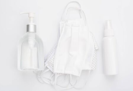 Fabric cloth mask for wearing germ protection  and gel alcohol or hand sanitizer spray bottle for washing hand  to protect from corona virus set on white background,flat layの写真素材
