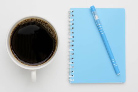 Coffee cup and blue notebook with pen on white background,top viewの写真素材