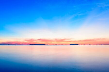 Beautiful beach sunset with blue sea and golden light sky  cloud background,long exposure techniqueの写真素材