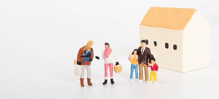 Miniature family people happy with a new house on white backgroundの写真素材