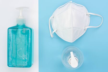 Surgical mask for wearing germ protection  and gel alcohol or hand sanitizer spray bottle for washing hand  to protect from corona virus set on blue and white background,flat layの写真素材