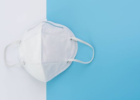 Surgical white mask for wearing germ protection to protect from corona virus set on blue and white  to tone background,top viewの写真素材