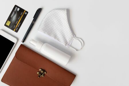 Women leather bag with necessary items cloth masks, spray alcohol, hand gel, credit card,pen and mobile phone for hygiene, cleaning and protect from Covid-19. Coronavirus,top viewの写真素材