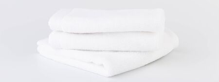 Stack of white towels on white backgroundの写真素材