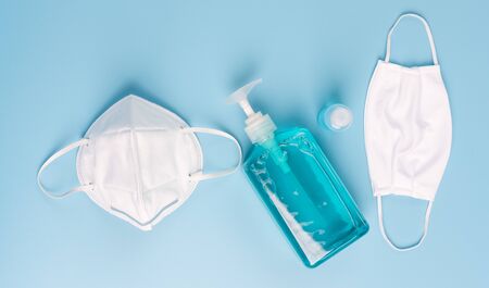 White mask for wearing germ protection  and gel alcohol or hand sanitizer spray bottle for washing hand  to protect from corona virus set on blue background,flat layの写真素材
