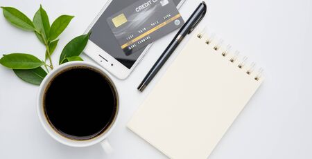 Work from home  with coffee cup, pen,credit card,smart phone  and notebook memo  on white background,flat layの写真素材