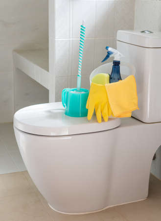 Basket of cleaning supplies on toilet bowl in modern bathroomの写真素材