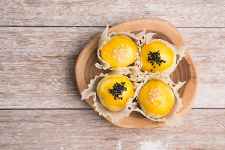 Chinese pastry bakery topping with black and white sesame seeds on wooden trayの写真素材
