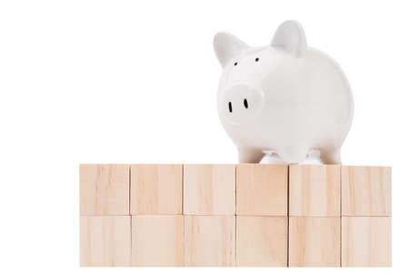 Wood cubes and piggy bank isolated on white backgroundの写真素材