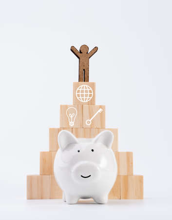 People model stand on wood cubes pyramid and piggy bank isolated on white background ,saving and invesment conceptの写真素材