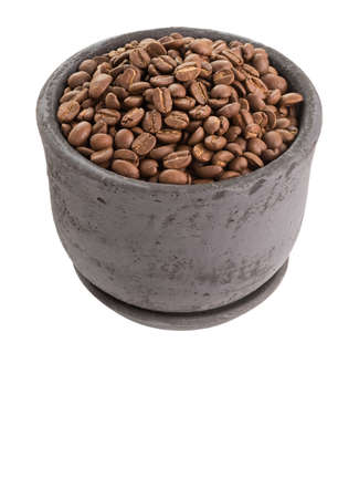 Roasted coffee beans in dark clay pot isolated on white backgroundの写真素材