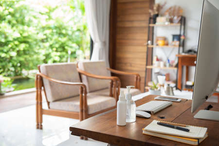 Work from home office gadget hygiene with computer and hand sanitizer protection from coronavirus outbreak or Covid-19  in living roomの写真素材
