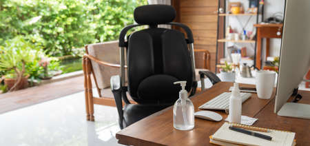 Work from home office gadget hygiene with computer and hand sanitizer protection from coronavirus outbreak or Covid-19  in living roomの写真素材