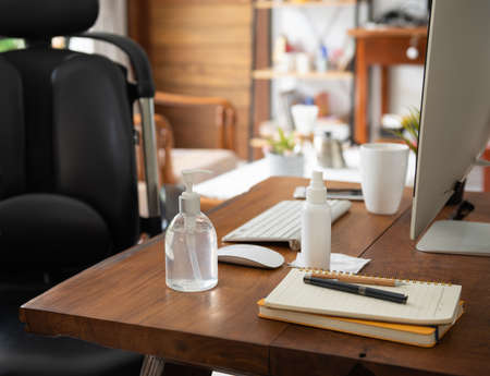Work from home office gadget hygiene with computer and hand sanitizer protection from coronavirus outbreak or Covid-19  in living roomの写真素材