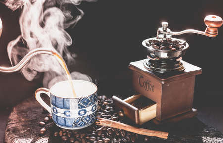 Coffee grinder,coffee beens and blue cup on grunge wood table dark backgroundの写真素材