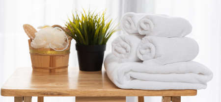 Bath and spa set homemade cosmetics set of natural products for body care and bath accessories with soap,scrub,candle,oil,comb, and white towels in white room interiorの写真素材