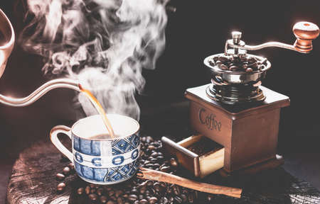 Coffee grinder,coffee beens and blue cup on grunge wood table dark backgroundの写真素材