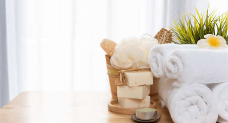 White towels,soap,luffa scrub,comb,candle and beautiful frangipani flower in clean white bathroomの写真素材
