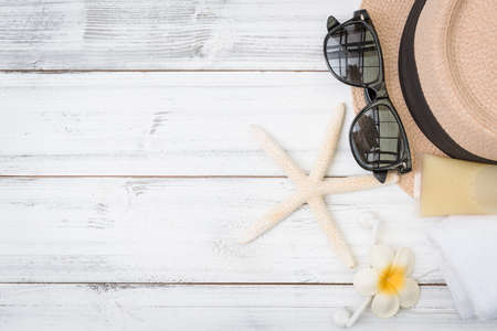 Summer background,straw hat ,towel,ear phone and sunglasses with star fish on white wood tableの写真素材