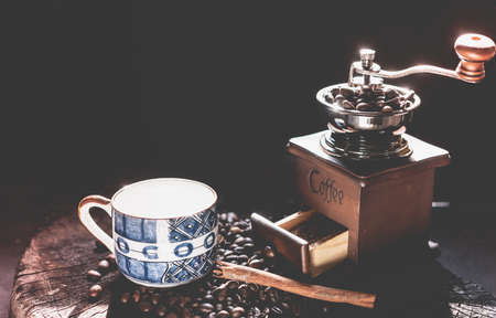 Coffee grinder,coffee beens and blue cup on grunge wood table dark backgroundの写真素材