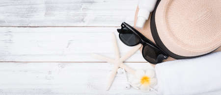 Summer background,straw hat ,towel,ear phone and sunglasses with star fish on white wood table,top viewの写真素材