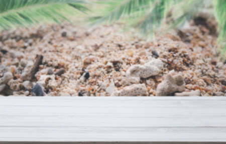 White wooden planks with blur beach on background and  palm leaves on foreground,summer conceptsの写真素材